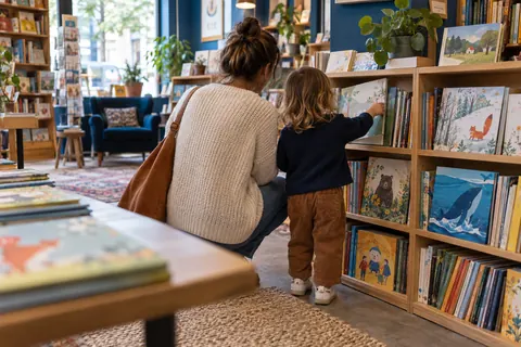 Illustration éditoriale : Parent et enfant choisissant ensemble un album illustré dans le rayon jeunesse d’une librairie